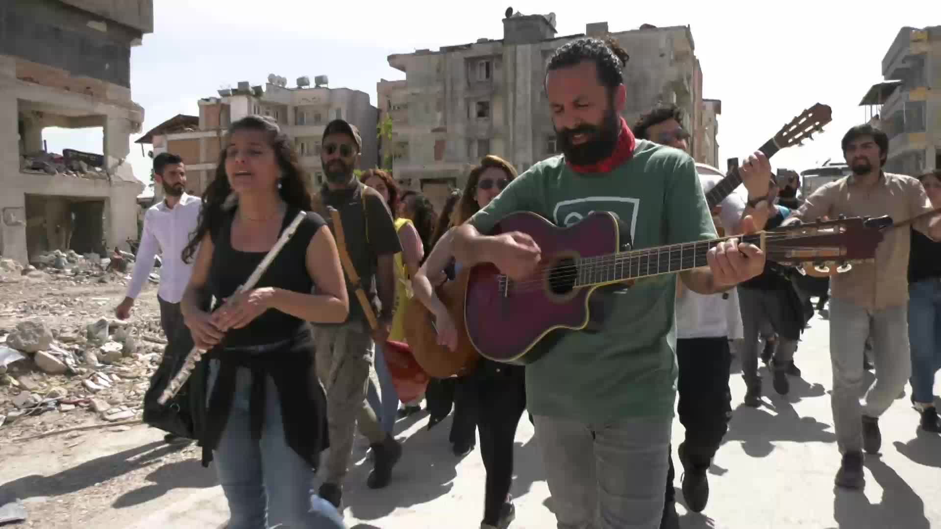 ANTAKYA’DA MÜZİSYENLER ŞARKILAR EŞLİĞİNDE YÜRÜDÜ: “BU ŞEHRİN YENİDEN KURULMASINDA BİZ DE VARIZ DİYORUZ. ANTAKYA’YI BIRAKMAYACAĞIZ”