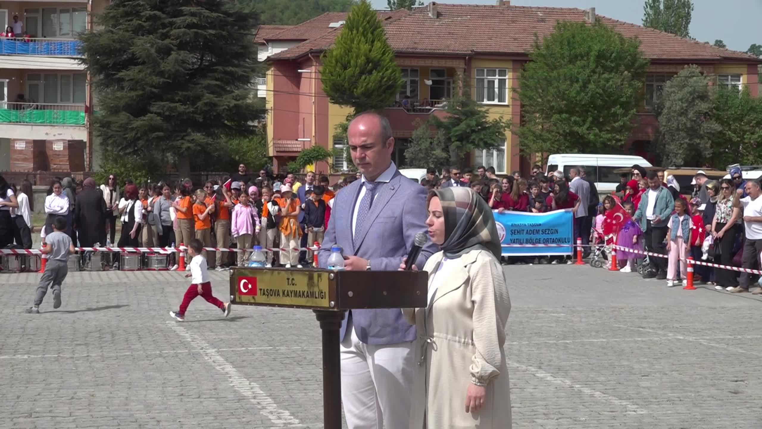 AMASYA'DA 23 NİSAN COŞKUYLA KUTLANDI:  HALK OYUNU OYNAYAN ÇOCUKLAR TÜRK BAYRAĞI'NI ÖPEREK KAYMAKAMA HEDİYE ETTİ