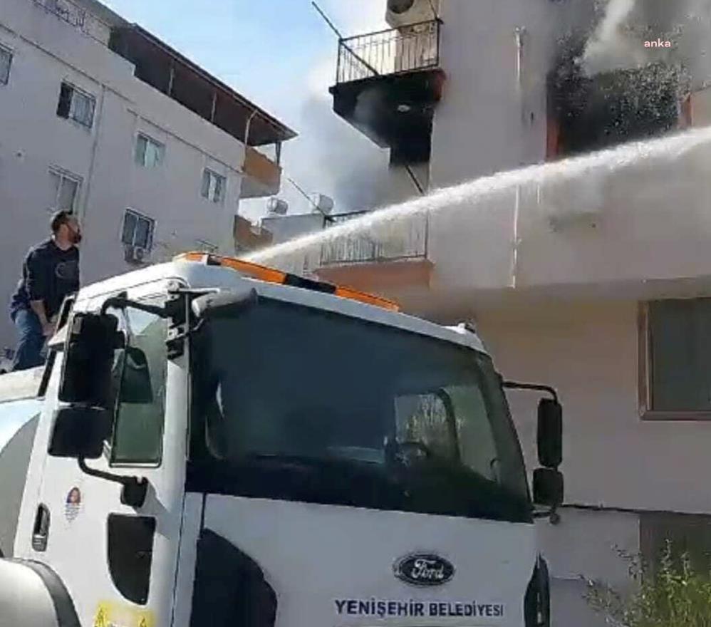 Parkta sulama yapan Yenişehir Belediyesi ekipleri, bir binanın ikinci katında çıkan yangını söndürdü